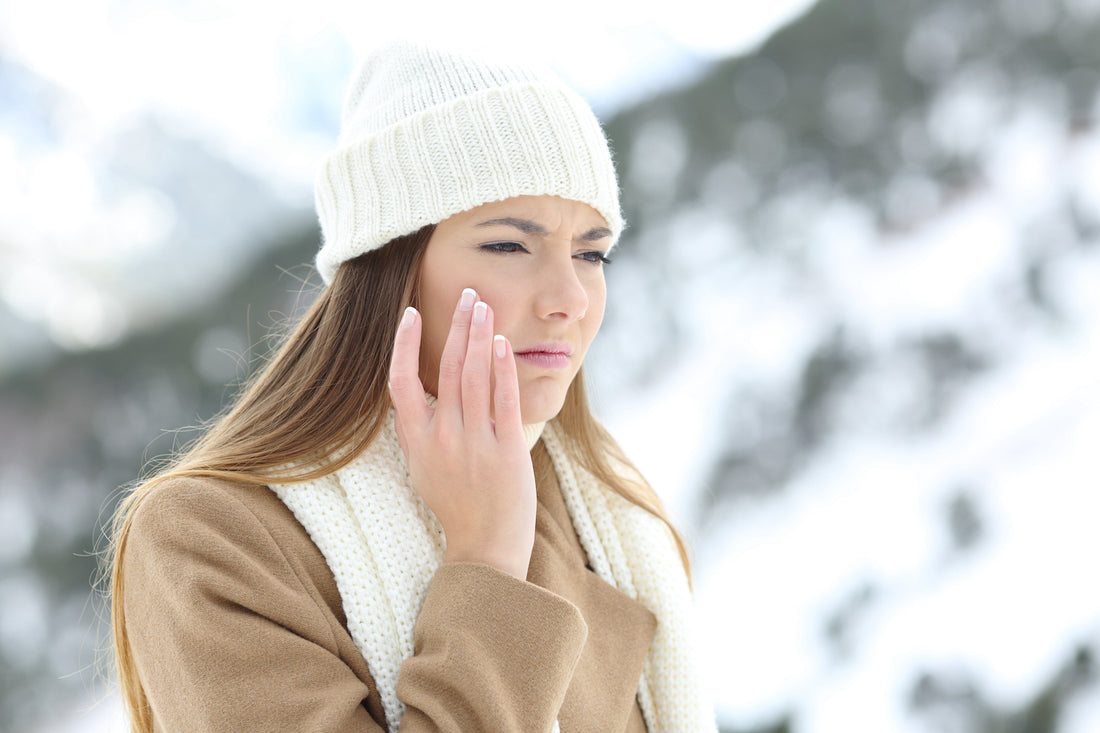 A woman is touching her face with an unpleasant look to indicate dry skin, a common skin concern, especially during the winter or in dry climates. 