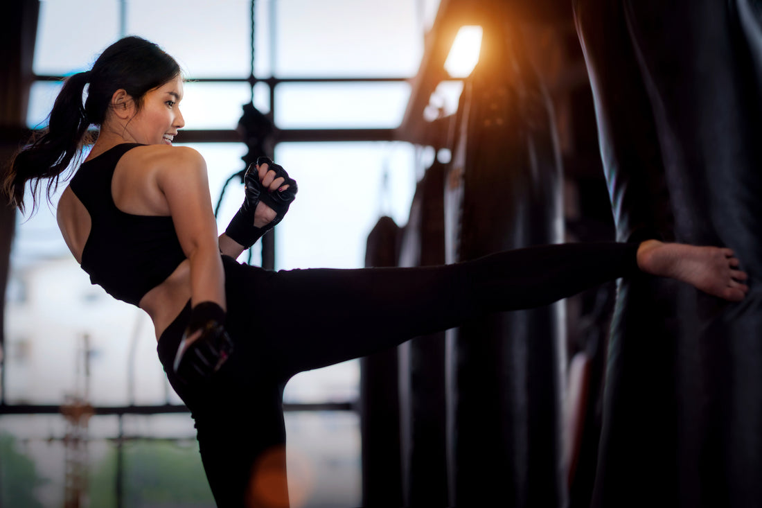 Woman kickboxing, looking forward to her post-workout skincare routine